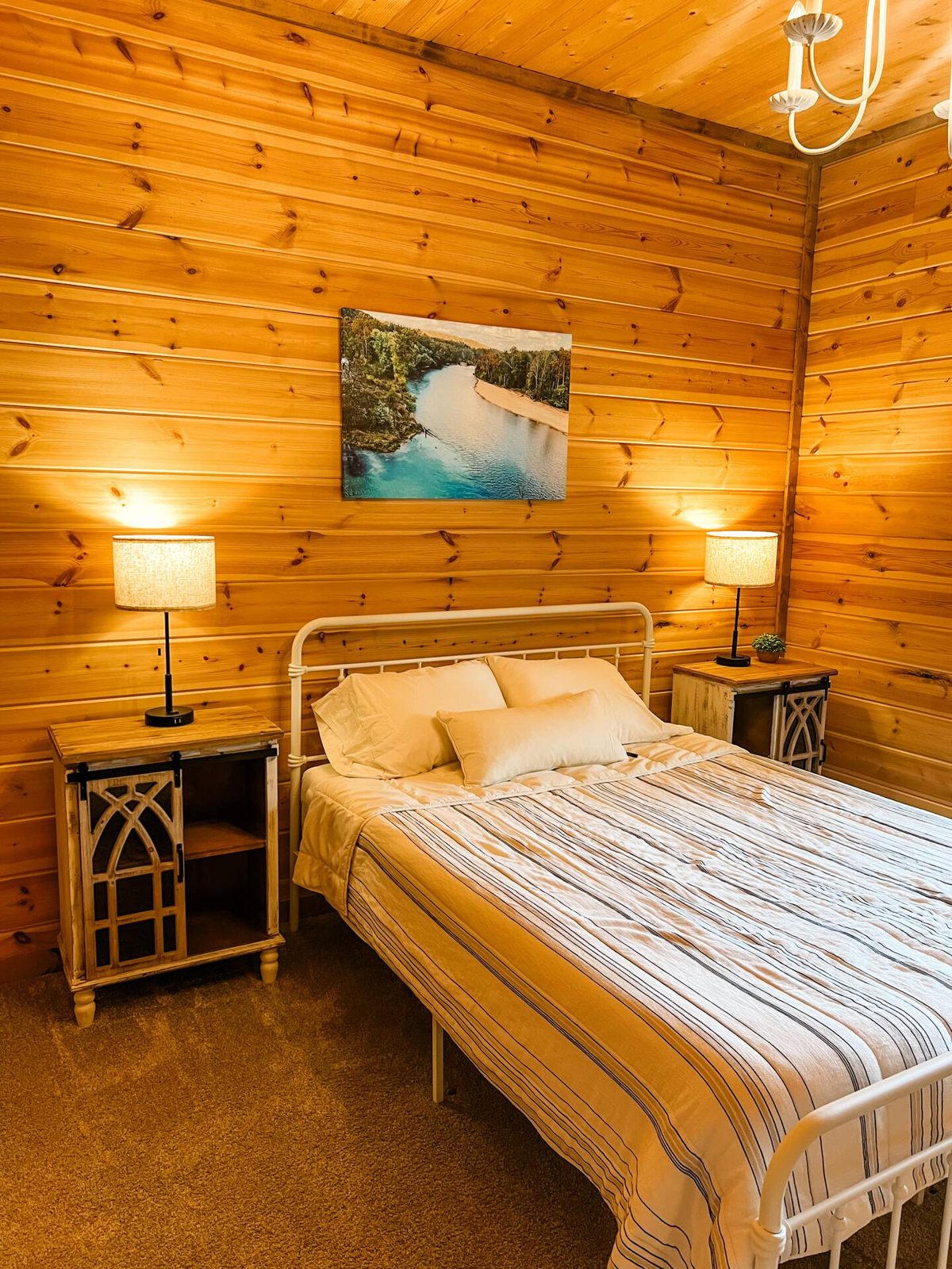 Queen bedroom with reading lamps and pine walls